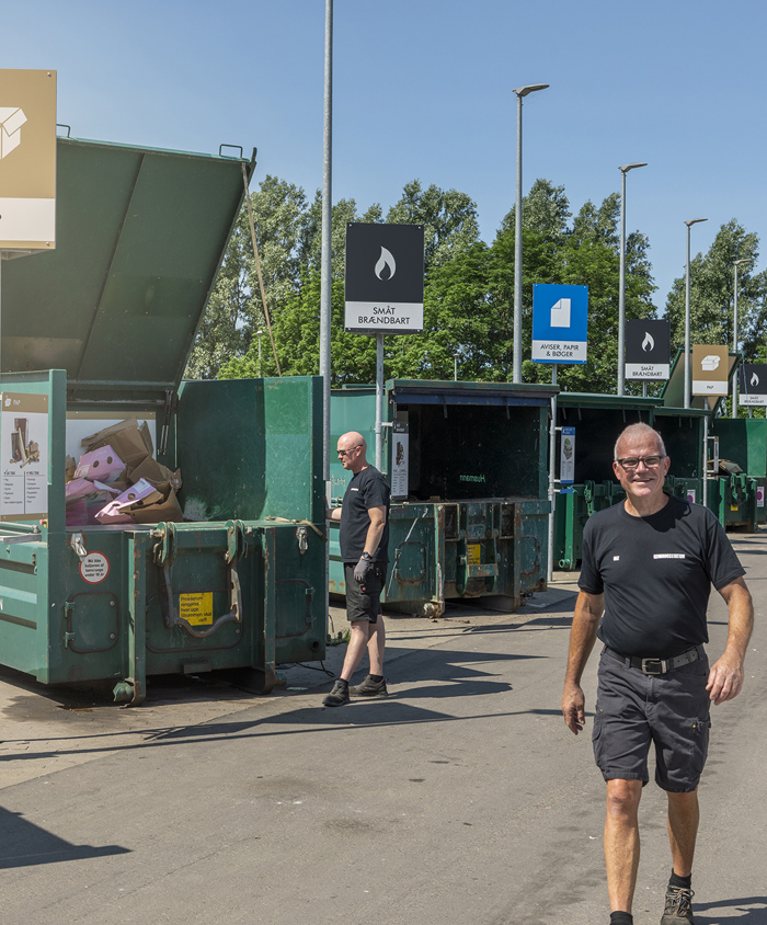 Genbrugsstation med sorteringscontainere og pladsmedarbejdere